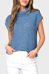 A woman wearing a blue funnel neck top with cap sleeves and a relaxed fit.