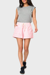 Full body view of Woman modeling Favorite Summer Short in Peach pink styled with t-shirt and sneakers