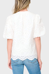 Back view of Woman modeling Bubble Sleeve Split Neck Top in White eyelet styled with denim