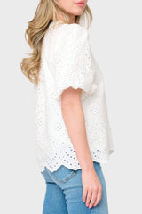 Side view of Woman modeling Bubble Sleeve Split Neck Top in White eyelet styled with denim
