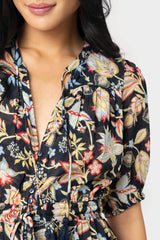 Close-up of women wearing the Elan Short Sleeve Tiered Floral Midi Dress in navy melrose print
