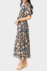 Side of women wearing the Elan Short Sleeve Tiered Floral Midi Dress in navy melrose print