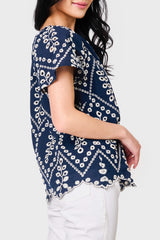 Side view of Woman modeling Flutter Sleeve Scallop Top in Navy Eyelet styled with casual pants