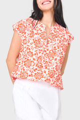 Woman modeling Cap Sleeve Notch Neck Blouse in Blossom haze coral floral styled for vacation, weekends, work and everyday