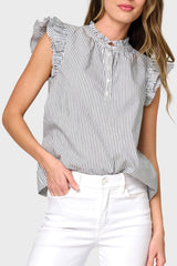 A woman wearing a striped top with double flutter sleeves and a Henley neckline, paired with white pants styled business casual