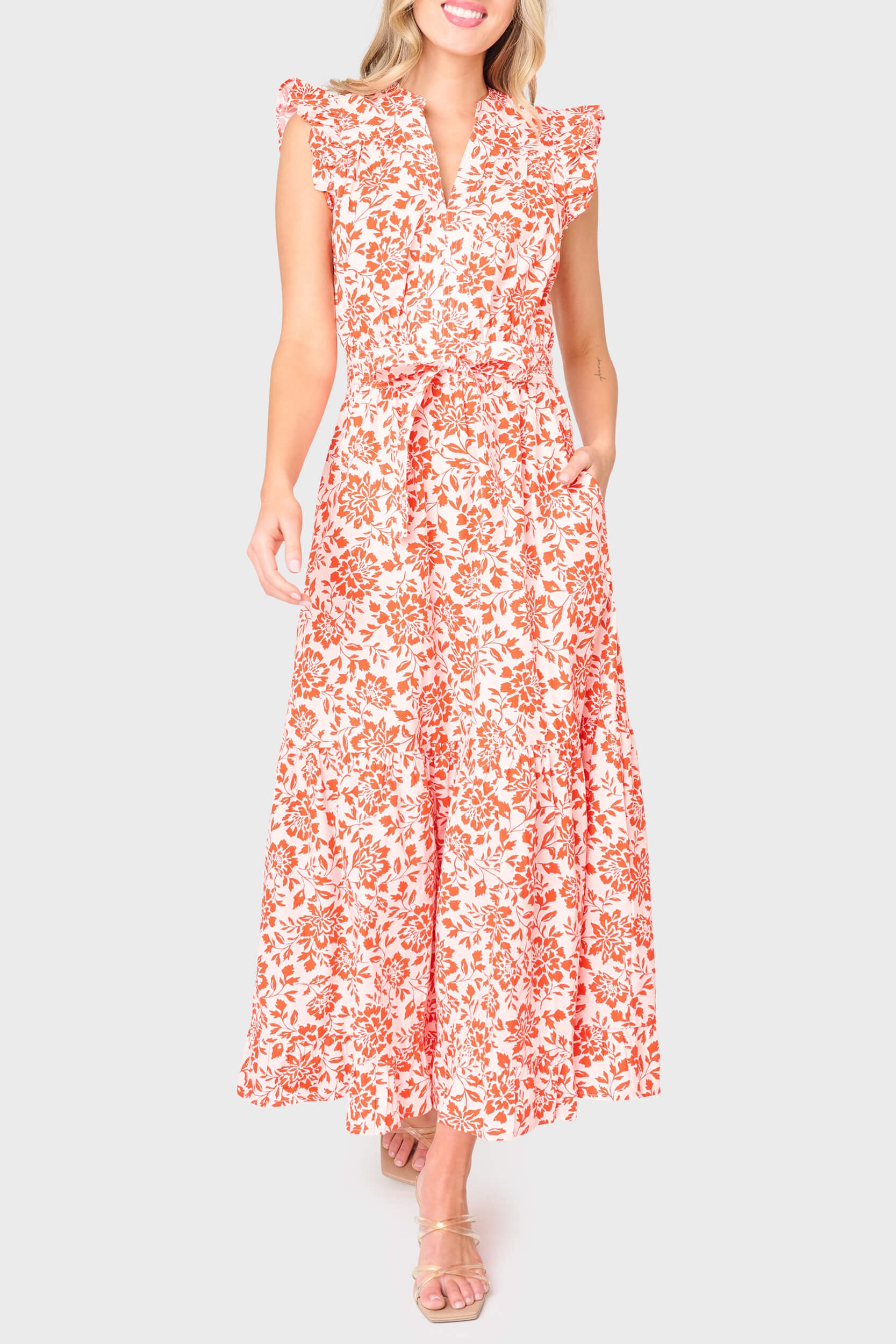 Woman modeling Notch Neck Flutter Sleeve Maxi Dress in Blossom Haze coral floral styled for work and everyday