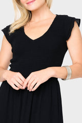 Detail of Woman modeling Flutter Sleeve Smocked V-Neck Tiered Maxi Dress in Black