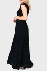 Side of Woman modeling Flutter Sleeve Smocked V-Neck Tiered Maxi Dress in Black, styled for work