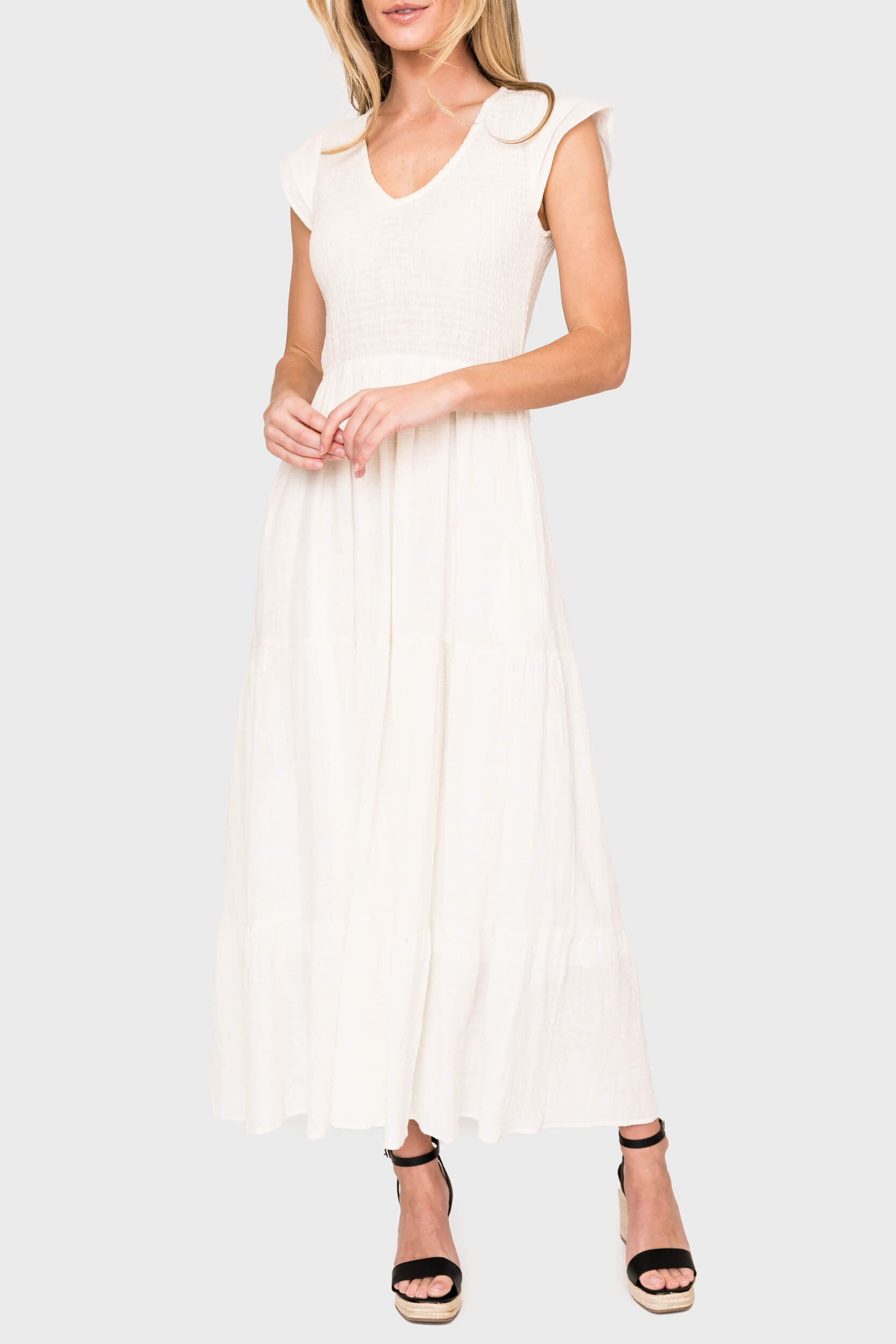 Woman modeling Flutter Sleeve Smocked V-Neck Tiered Maxi Dress in Off White styled for work