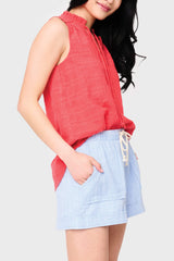 Side view of Woman modeling Cameron Day Top with Crochet Trim in Hibiscus red styled with casual shorts