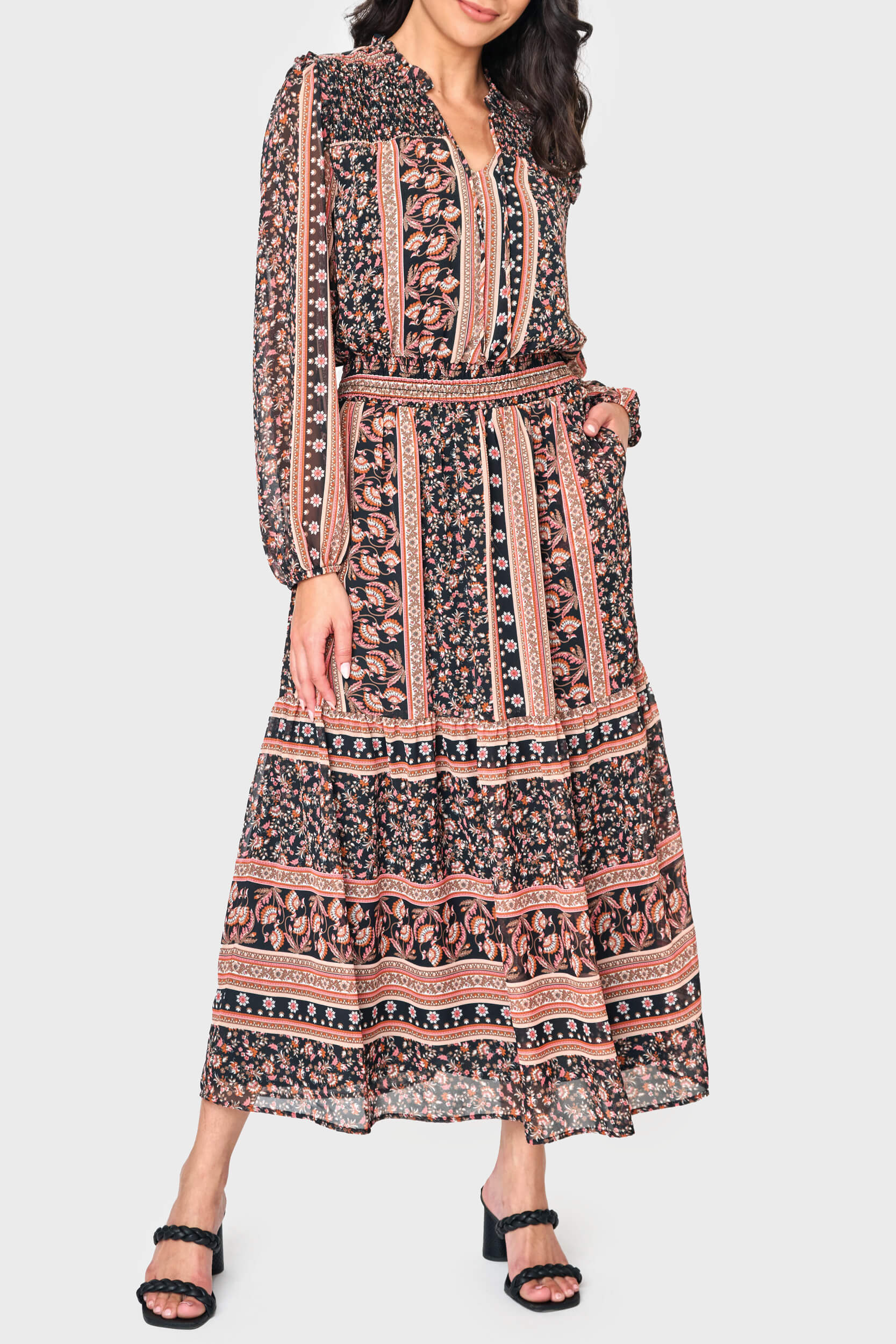 Woman modeling boho Leyla Smocked Maxi Dress in coral black print styled business casual
