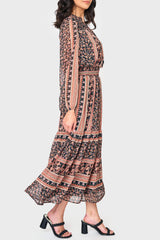 Side of Woman modeling boho Leyla Smocked Maxi Dress in coral black print styled business casual