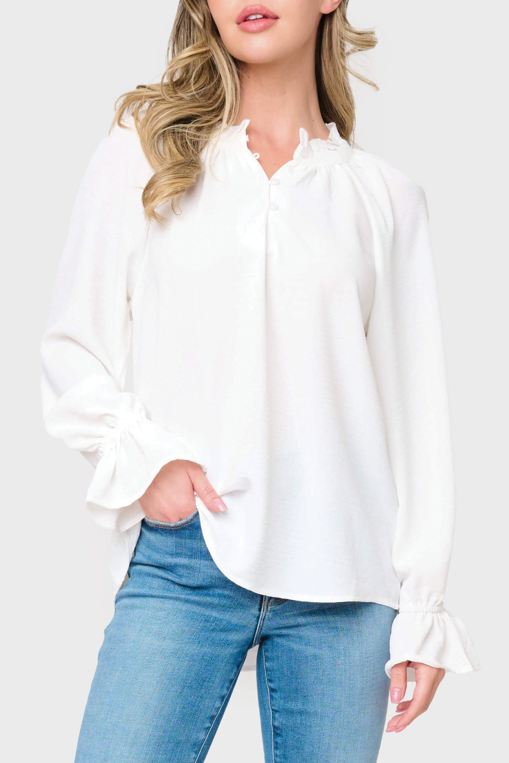 Woman modeling Chloe Boho Ruffle Detail Blouse in White styled with denim pants