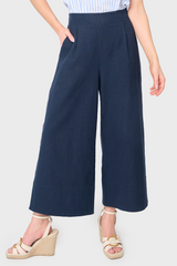 Woman modeling Wide Hem Cropped Linen Pant in Navy styled with blouse and sandals