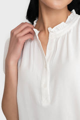 Detail of Model wearing Dianthus Henley Puff Sleeve Blouse in White ruffle henley neckline for summer