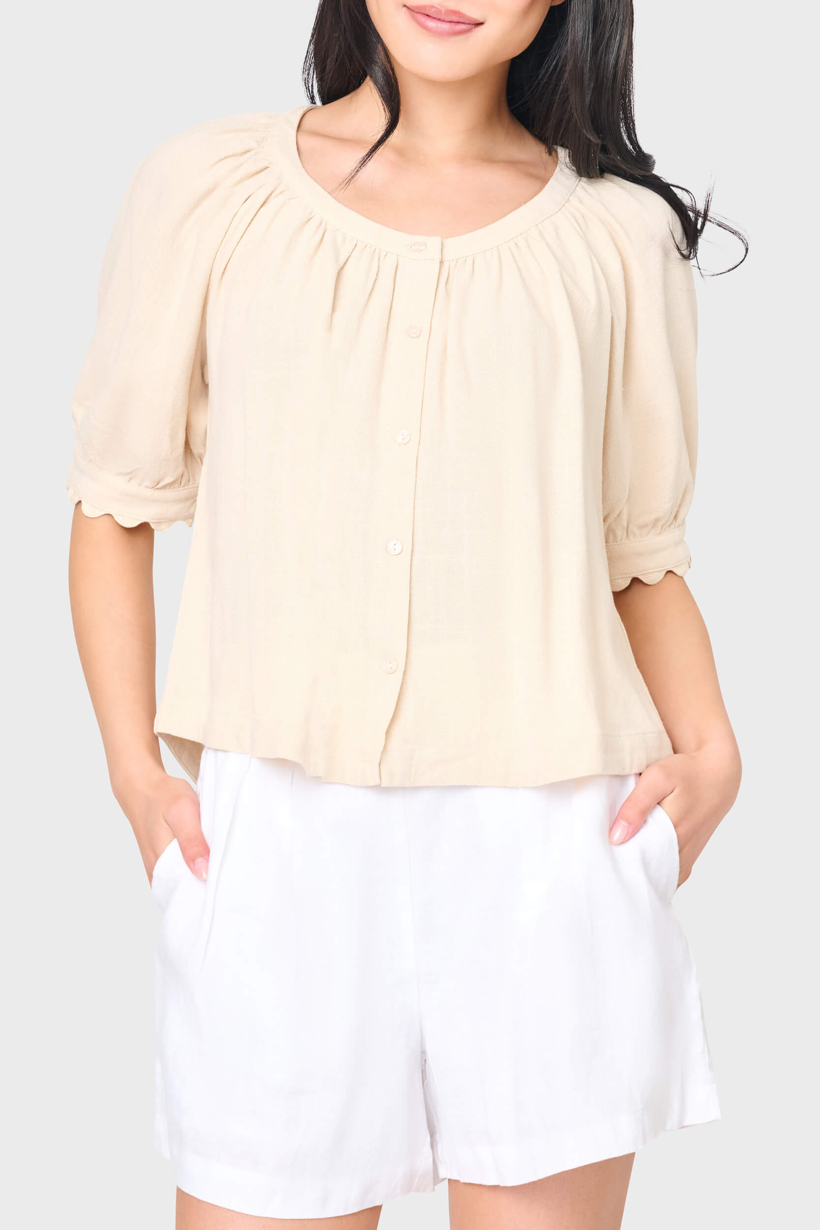 Woman modeling Lily Scallop Puff Sleeve Linen Top in Natural beige styled for vacations and weekends