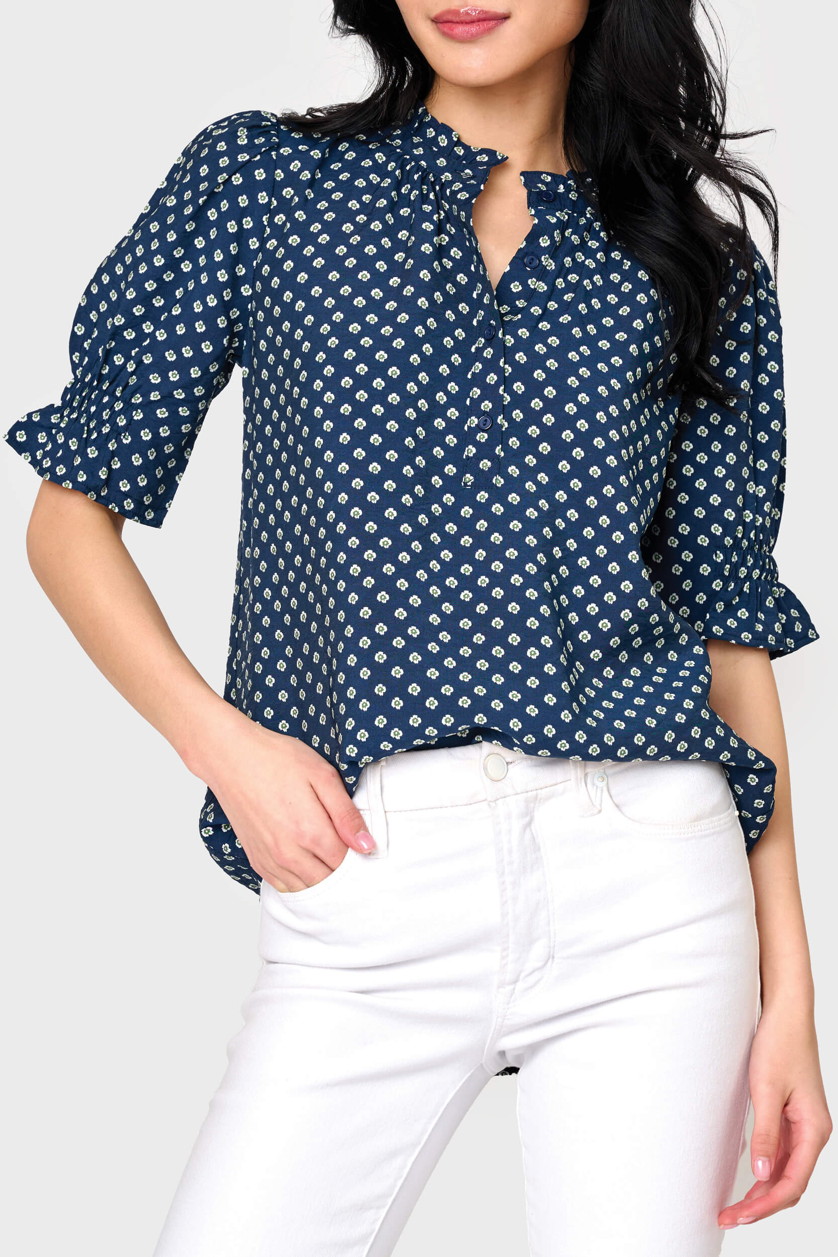Woman modeling Dianthus Henley Puff Sleeve Blouse in Navy Daisy print styled with casual pants