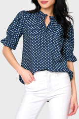 Woman modeling Dianthus Henley Puff Sleeve Blouse in Navy Daisy print styled with casual pants