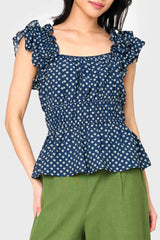Woman modeling Elle Boho Flutter Sleeve Top in Navy Daisy print styled with trousers