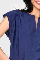 Woman modeling Cap Sleeve Notch Neck Blouse in Navy blue split neckline detail