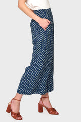 Side view of Woman modeling Wide Hem Cropped Linen Pant in Navy Daisy print styled with tee and sandals