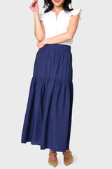 Full body view of Woman modeling Playa Tiered Maxi Skirt in Navy styled with heels and blouse