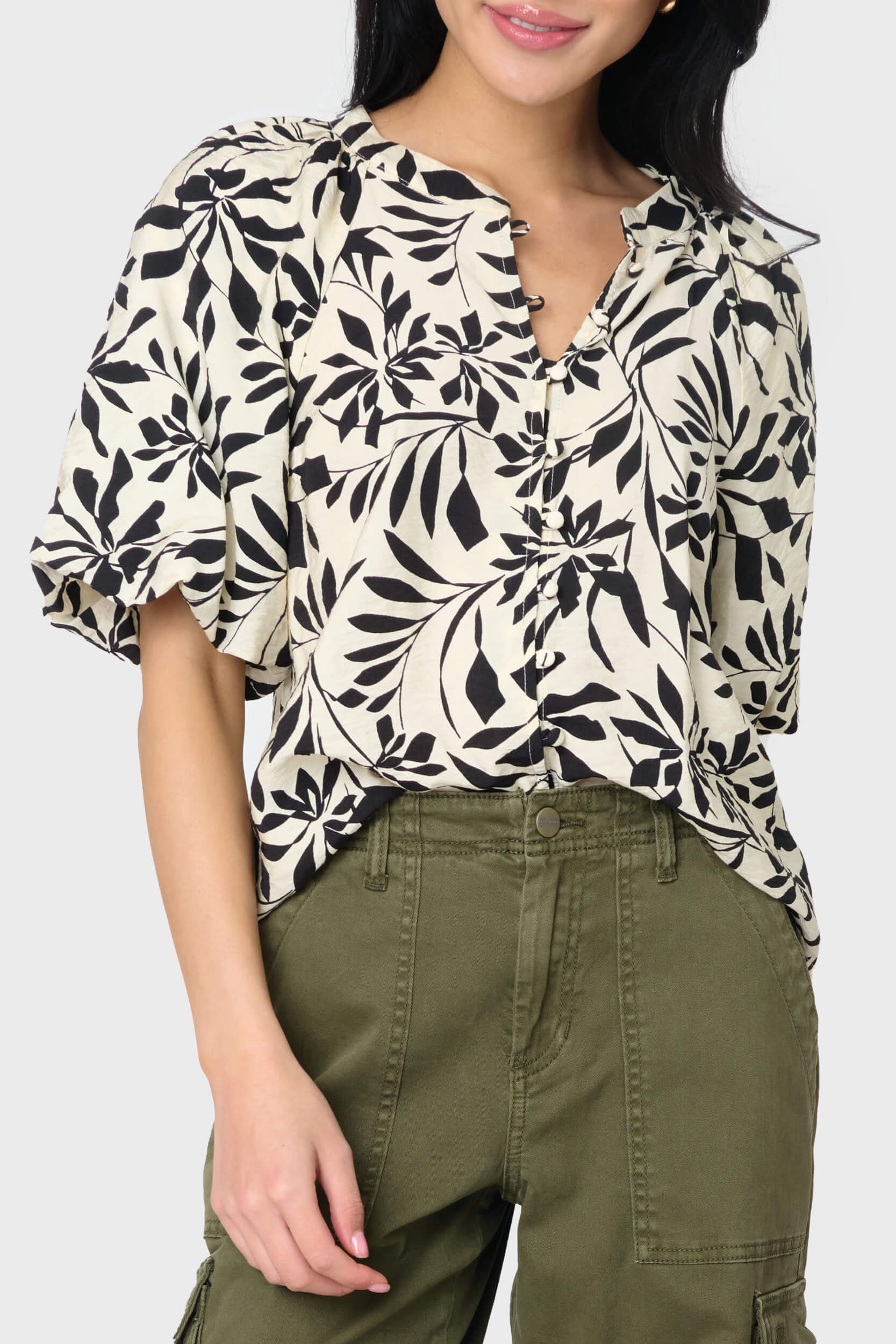 A woman wearing a floral bell sleeve button blouse with long sleeves, paired with green cargo pants styled weekend casual