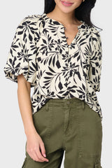 A woman wearing a floral bell sleeve button blouse with long sleeves, paired with green cargo pants styled weekend casual