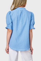 Back view of Model wearing Dianthus Henley Puff Sleeve Blouse in textured Blue Skies, styled for work