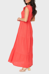 Side of Woman modeling Flutter Sleeve Smocked V-Neck Tiered Maxi Dress in Tangerine Orange styled for work