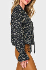 Side of Woman modeling Long Sleeve Surplice Blouse With Ruffle Sleeve in Black boho floral print styled for work