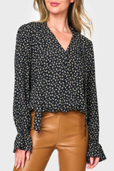 Woman modeling Long Sleeve Surplice Blouse With Ruffle Sleeve in Black boho floral print styled for work