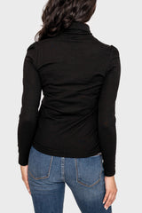 Back of Woman modeling Essential Turtleneck Soft Sweater Knit Top with Puff Sleeve in Black styled for layering
