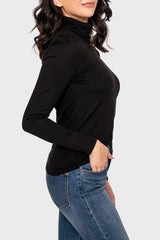 Side of Woman modeling Essential Turtleneck Soft Sweater Knit Top with Puff Sleeve in Black styled for layering