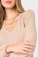 Detail of woman modeling Woman modeling V-Neck Blouson Sleeve Sweater in Taupe tan, perfect for layering