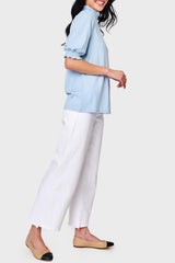 Side view of Woman modeling Feminine Mock Neck Luxe Sweater in Cashmere Blue styled with casual pants