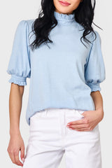 Woman modeling Feminine Mock Neck Luxe Sweater in Cashmere Blue styled with casual pants