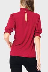 Keyhole back of Woman modeling Feminine Mock Neck Luxe Sweater Top in Cranberry red styled business casual