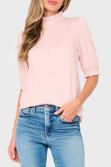 Woman modeling Feminine Mock Neck Luxe Sweater Top in light pink smoke styled everyday casual
