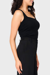 Side of Woman modeling Feminine Luxe Sweater Tank in Black styled as layer for work