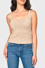 A sleeveless beige knit sweater tank top with square neck and back, worn by a female model paired with blue jeans.
