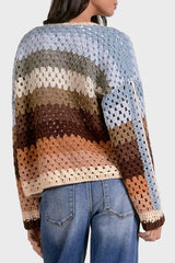 Woman wearing a colorful, patterned sweater against a plain background