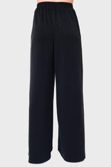 Back View Woman modeling Soft Cloud Scuba Luxe Everywhere Pant in black, styled with sneakers