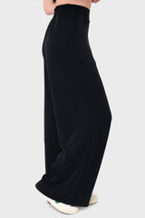 Side View Woman modeling Soft Cloud Scuba Luxe Everywhere Pant in black, styled with sneakers