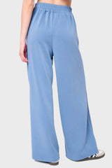 Back View Woman modeling Soft Cloud Scuba Luxe Everywhere Pant in denim blue, styled with sneakers