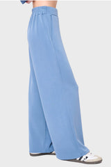 Side View Woman modeling Soft Cloud Scuba Luxe Everywhere Pant in denim blue, styled with sneakers