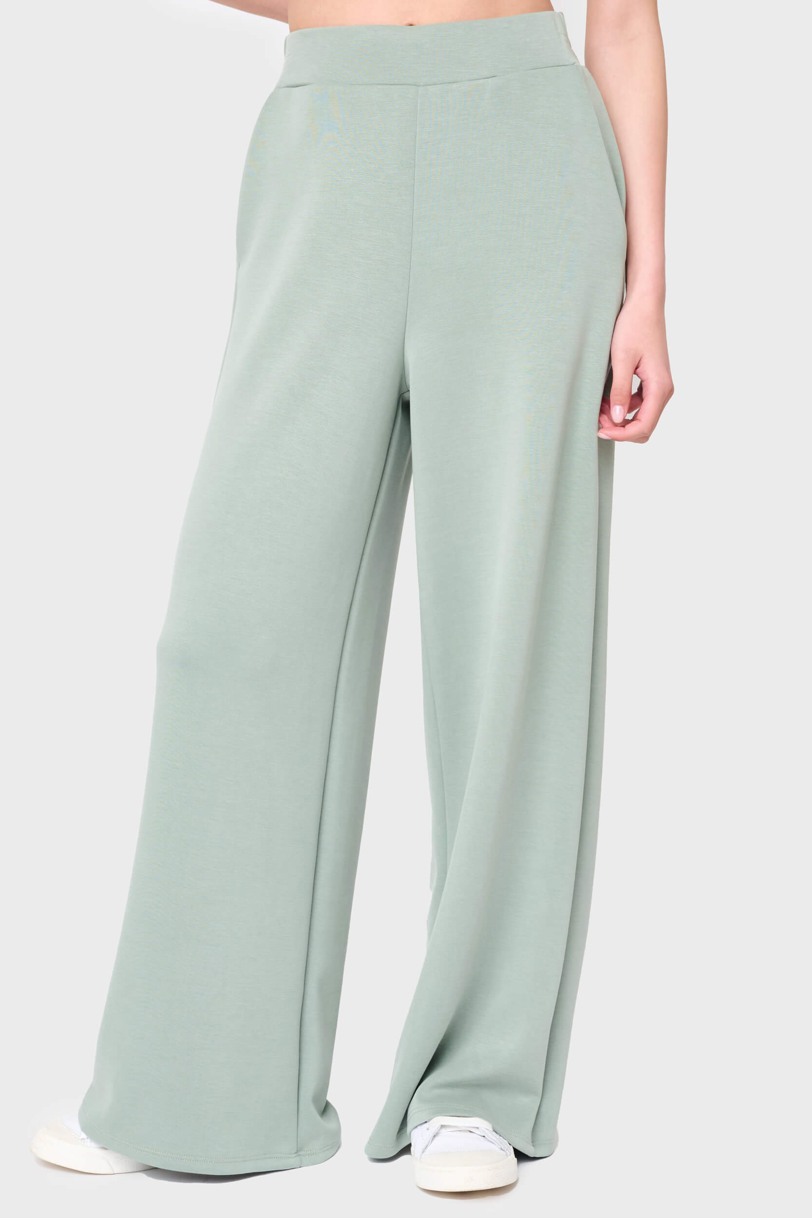 Woman modeling Soft Cloud Scuba Luxe Everywhere Pant in sage green, styled with sneakers
