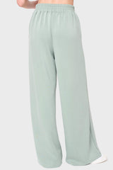 Back view Woman modeling Soft Cloud Scuba Luxe Everywhere Pant in sage green, styled with sneakers