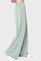 Side View Woman modeling Soft Cloud Scuba Luxe Everywhere Pant in sage green, styled with sneakers