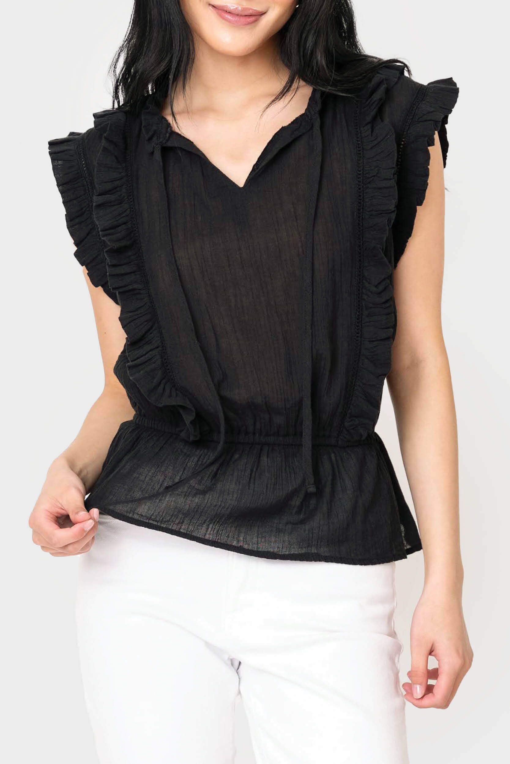 Front of women wearing the Elan Sleeveless Ruffle Trim Blouse in black